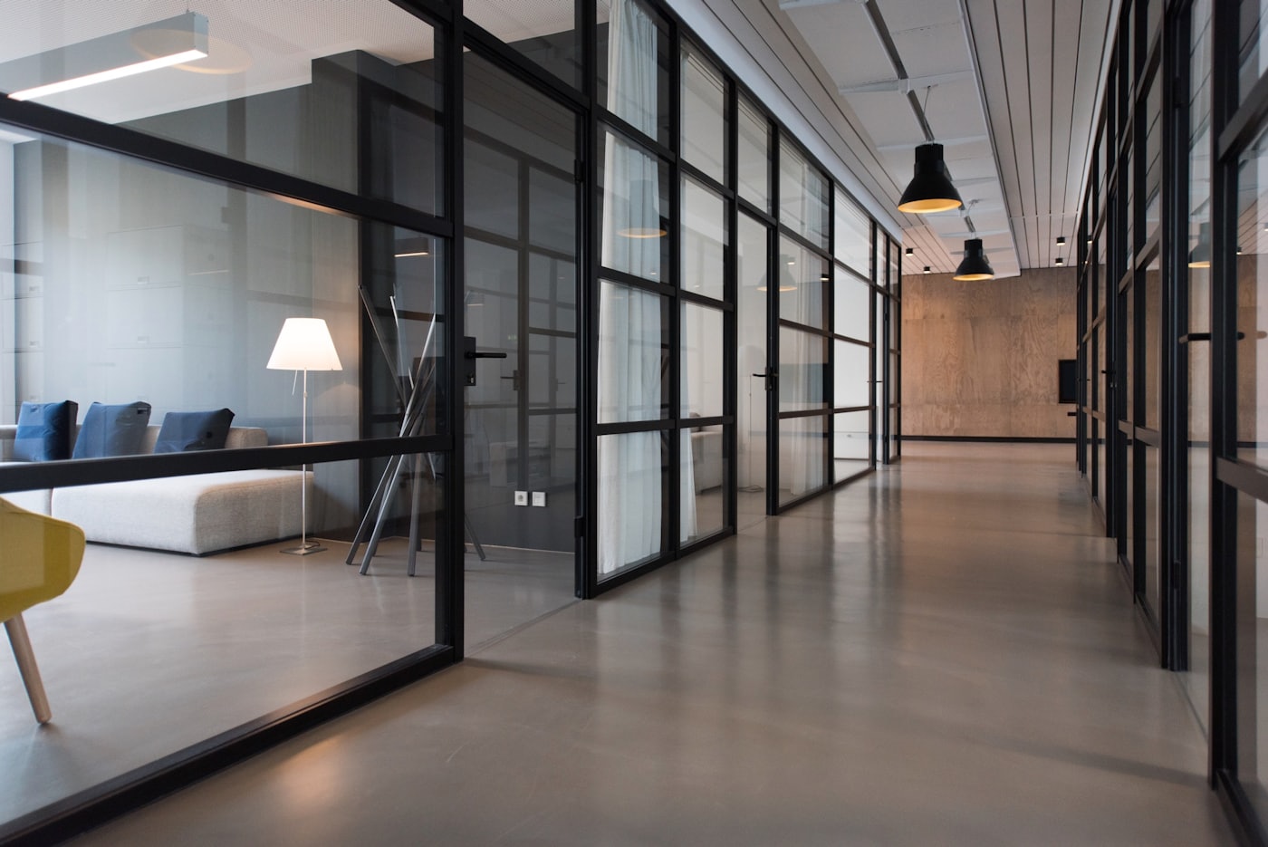 Couloir d'un plateau de bureaux vitré, sans occupant